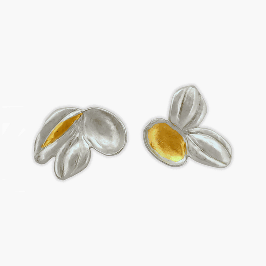 Close-up image of delicate sterling silver stud earrings featuring seedling forms with 24k gold foil accents. Each earring measures 3/4" and weighs 1.8g. Hand-chased and repoussed craftsmanship. Handcrafted by the artist in British Columbia.