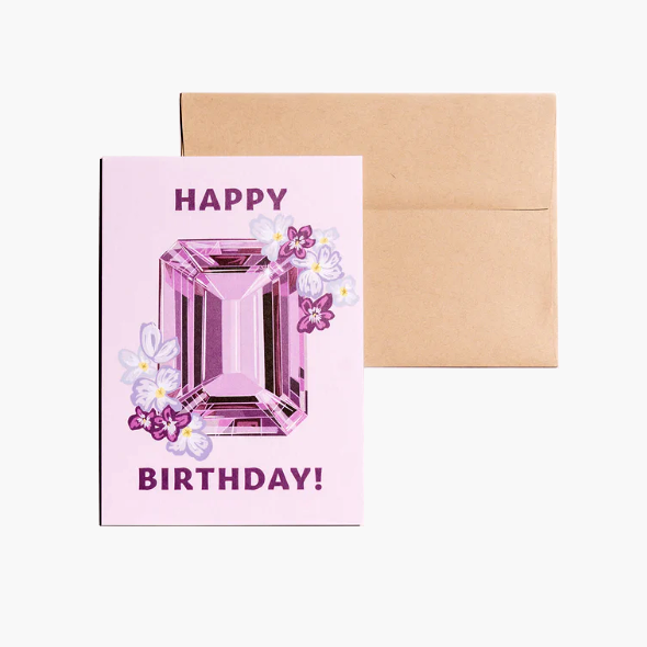 Birthday card showcasing an illustrated February birthstone of amethyst and birth flowers of violets and primrose.
