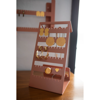 Versatile tabletop jewelry organizer in coral red featuring compartments for earrings, hooks for necklaces, and slots for rings. 