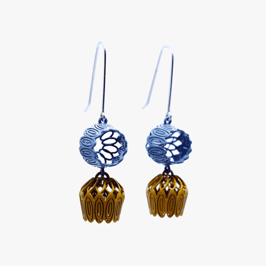 Image of Double Tulip Drop earrings showcasing a three-dimensional open-work tulip design. The earrings feature two tulips in blue and deep yellow, delicately cascading from one another, creating a subtle play of length. Crafted by artist Sorrel Van Allen, the earrings boast sterling silver ear hooks and intricate tulip motifs. 