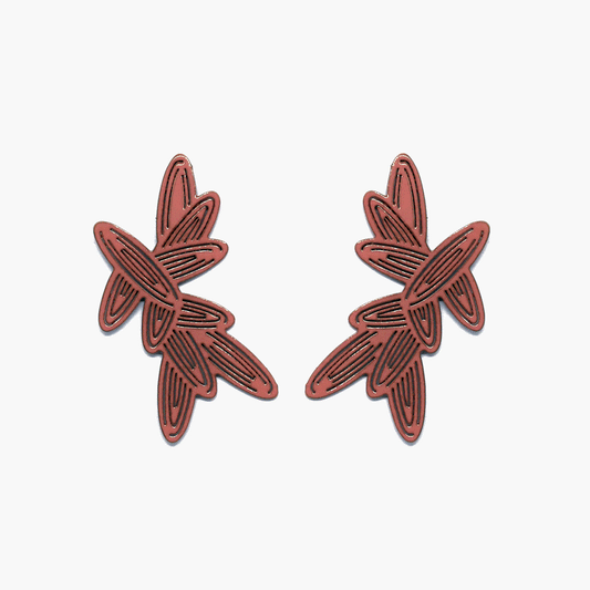 A stunning pair of coral-colored earrings with intricate pierced details. The earrings are flat in design and beautifully mirror each other, creating an elegant and symmetrical accessory.