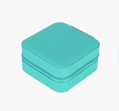 Small square turquoise jewellery travel case.  The case has a zipper and holds four pairs of earrings, six rings and three chains.