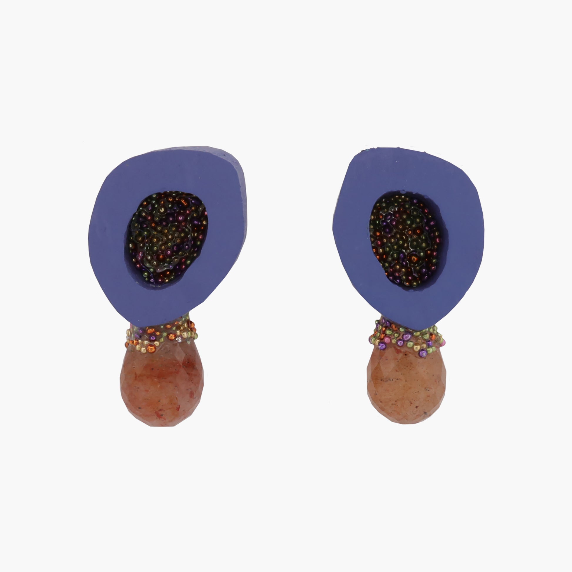 A pair of bone and gemstone stud earrings by Chantel Gushue. The earrings have glass bead details inside the bone and around the gemstone. The earring are shown on a bright background.