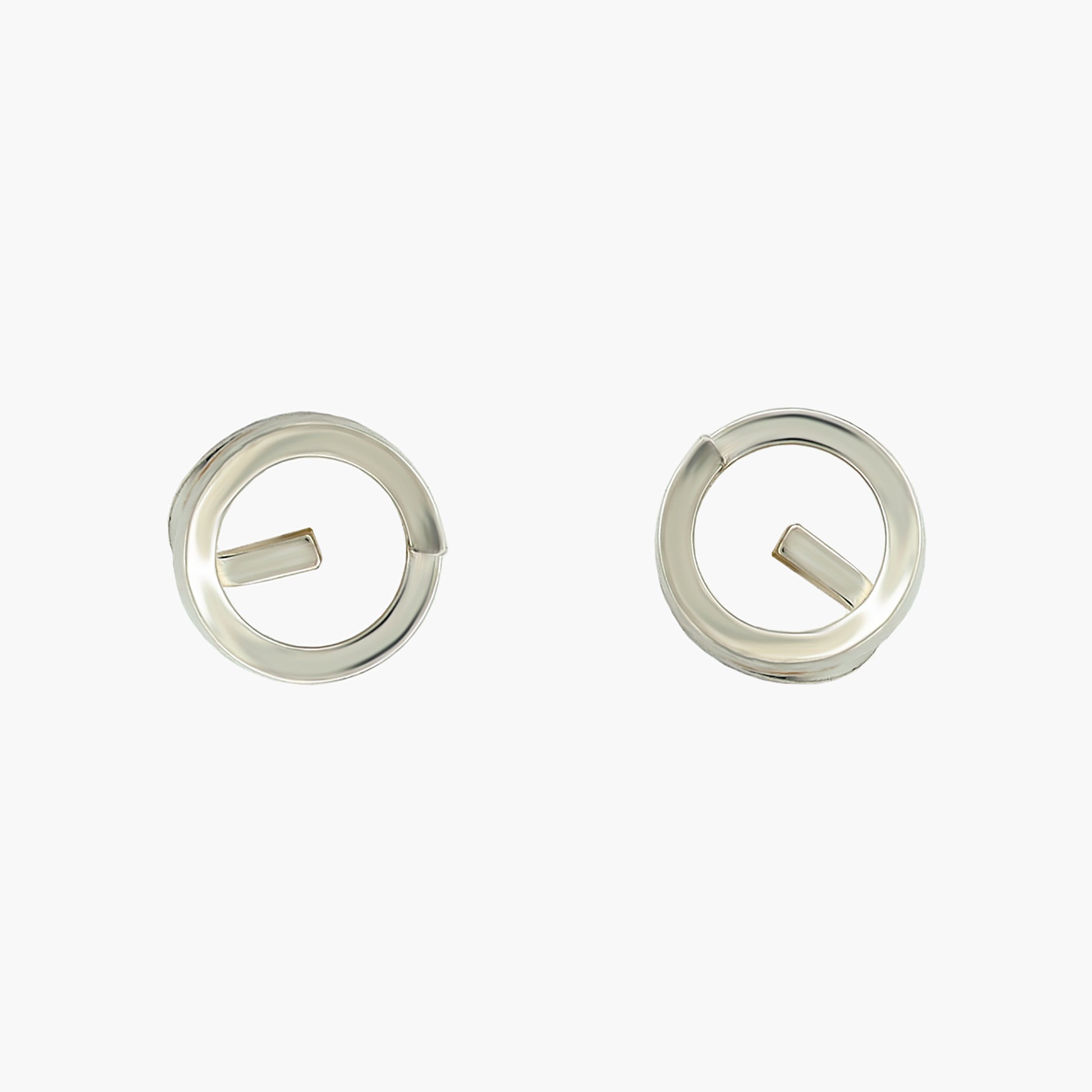 One pair of small sterling silver stud earrings by Dorothée Rosen, made from a coil of square wire to inspire the idea of a clock face. The earrings are set on a bright background.