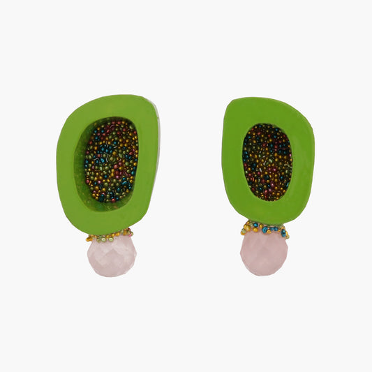 A pair of bone and gemstone stud earrings by Chantel Gushue. The earrings have glass bead details inside the bone and around the gemstone. The earring are shown on a bright background.